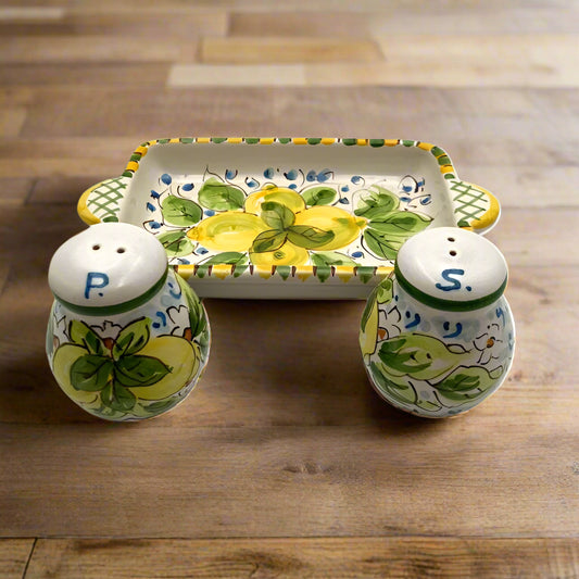 Ceramic salt and pepper shakers with a matching tray on a white background