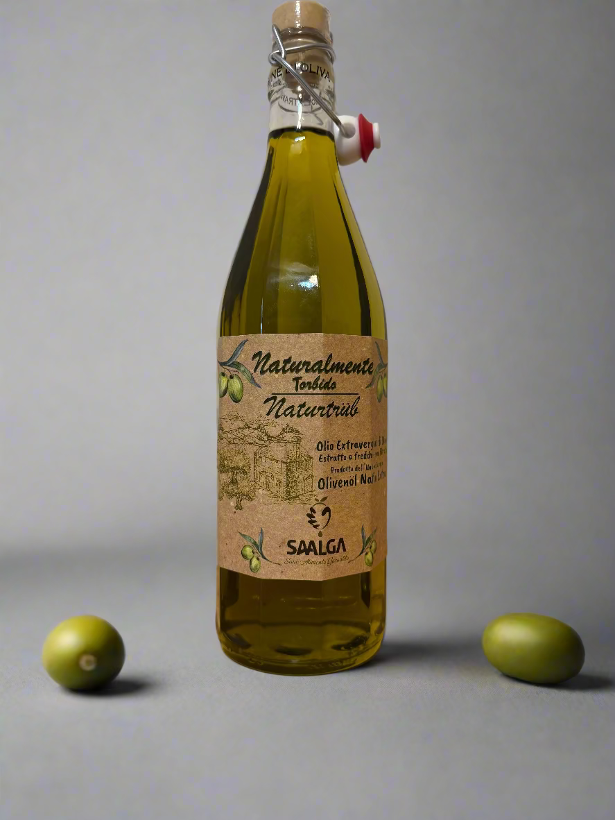 Bottle of olive oil with a label on a wooden surface and white wall background