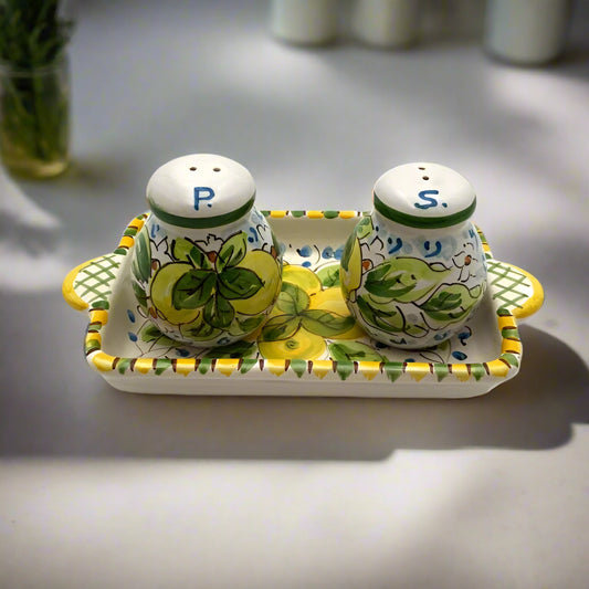 Ceramic salt and pepper shakers with a tray on a white background