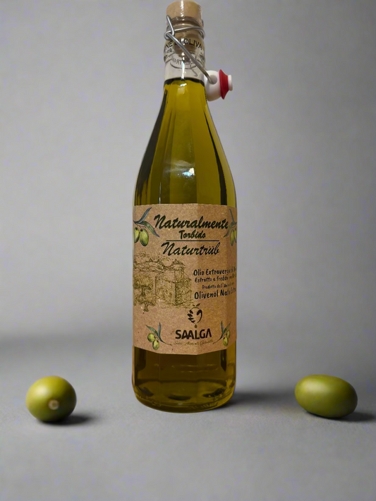 Bottle of olive oil with a label on a wooden surface and white wall background